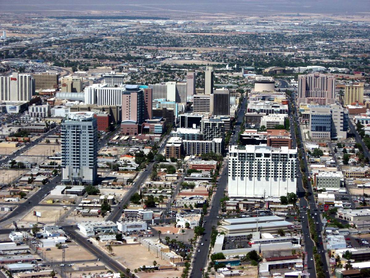 Aerial view of downtown Las Vegas high-rise buildings and streets stretching toward a desert valley
