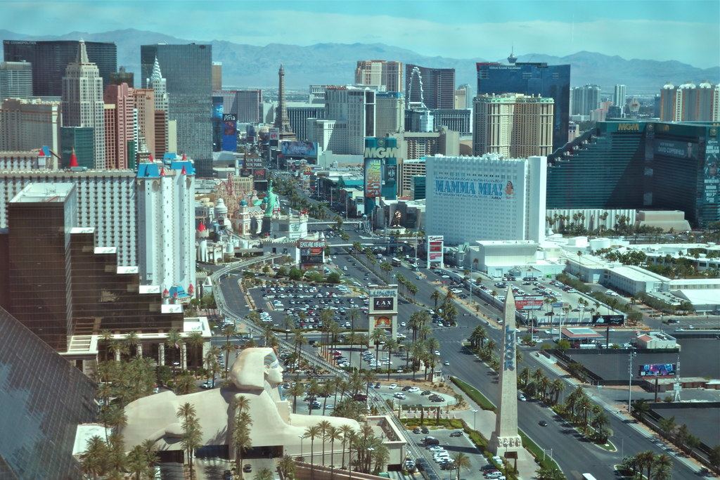 Aerial view of the Las Vegas Strip with the Luxor sphinx and obelisk, Excalibur, MGM Grand and mountains