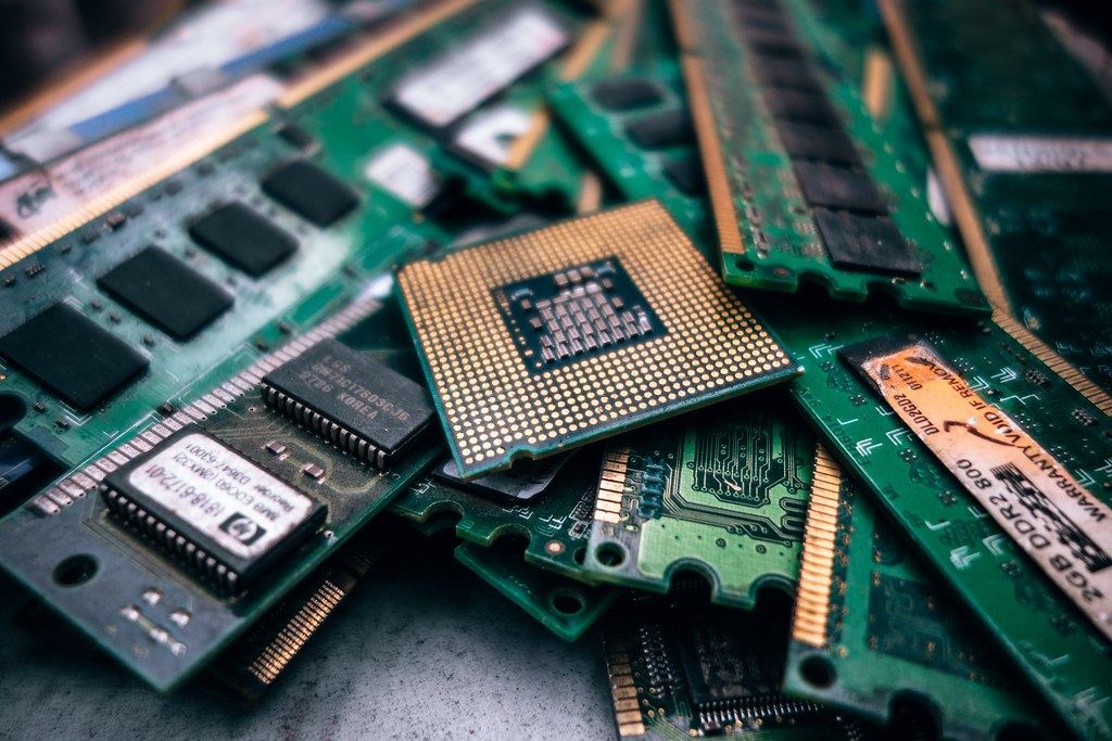 Close-up of a computer processor resting on a pile of green RAM memory modules