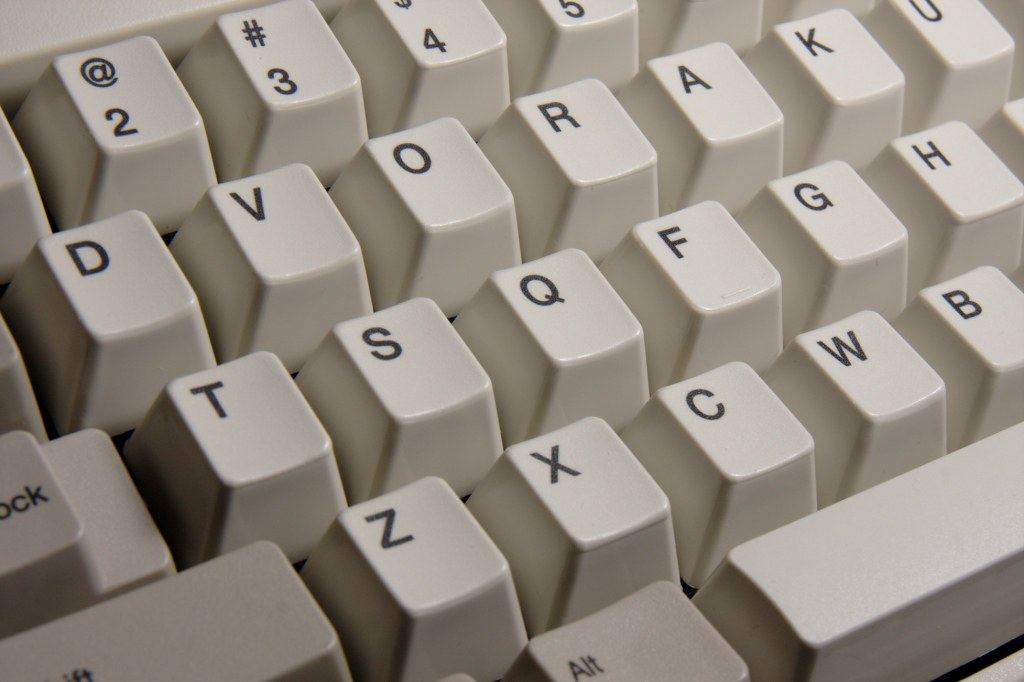 Close-up of beige computer keyboard keys with black letters and numbers in a scrambled layout