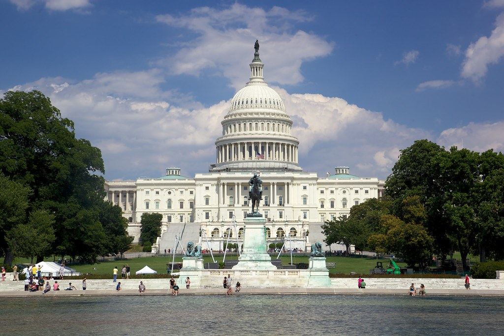 The U.S. Capitol dome and west front behind the Grant Memorial and reflecting pool on a sunny day