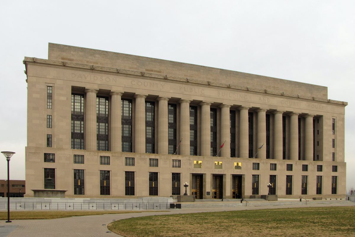 Limestone facade of the Davidson County Public Building and Courthouse with tall columns and a lawn in front
