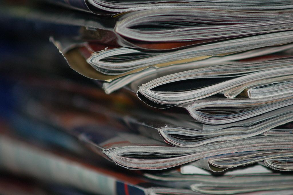 Close-up of the curled page edges of a tall stack of magazines or periodicals
