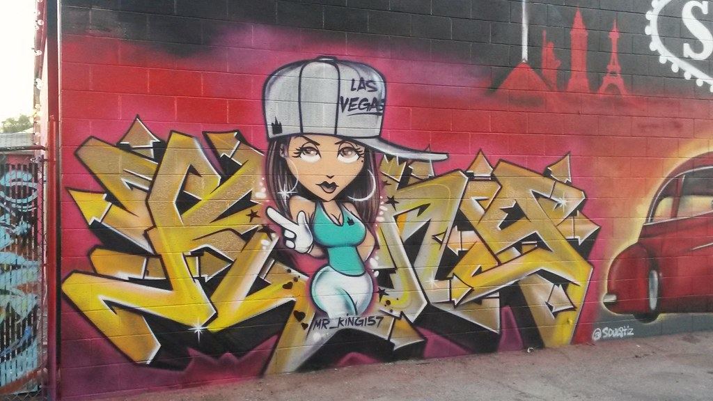 Colorful graffiti mural of a cartoon girl in a Las Vegas cap with gold lettering and a red car on a block wall