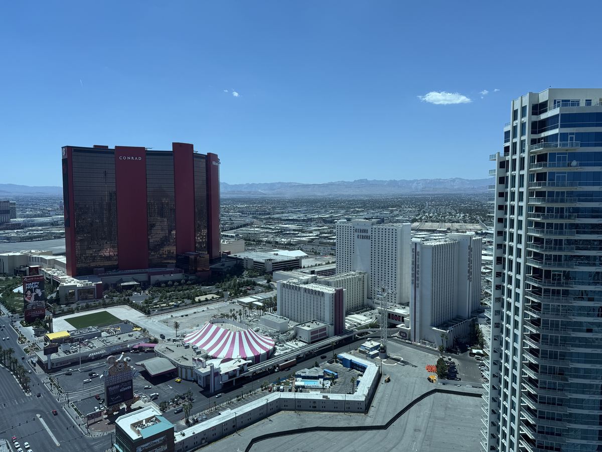 Aerial view of Circus Circus hotel towers and pink striped dome on the Las Vegas Strip, with mountains beyond
