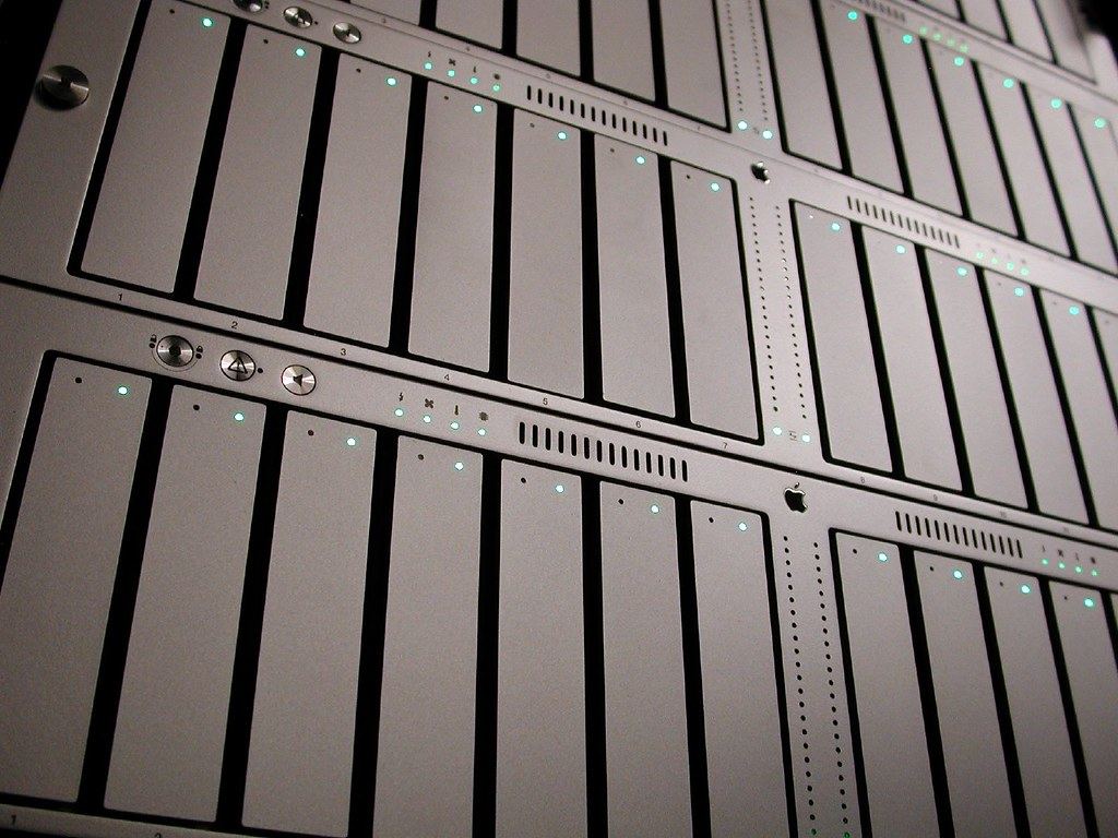 Close-up of rack-mounted silver storage servers with rows of drive bays and small glowing status lights