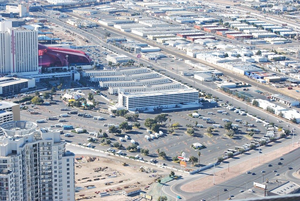 Aerial view of Las Vegas hotels, a large RV park and low commercial buildings beside a wide road