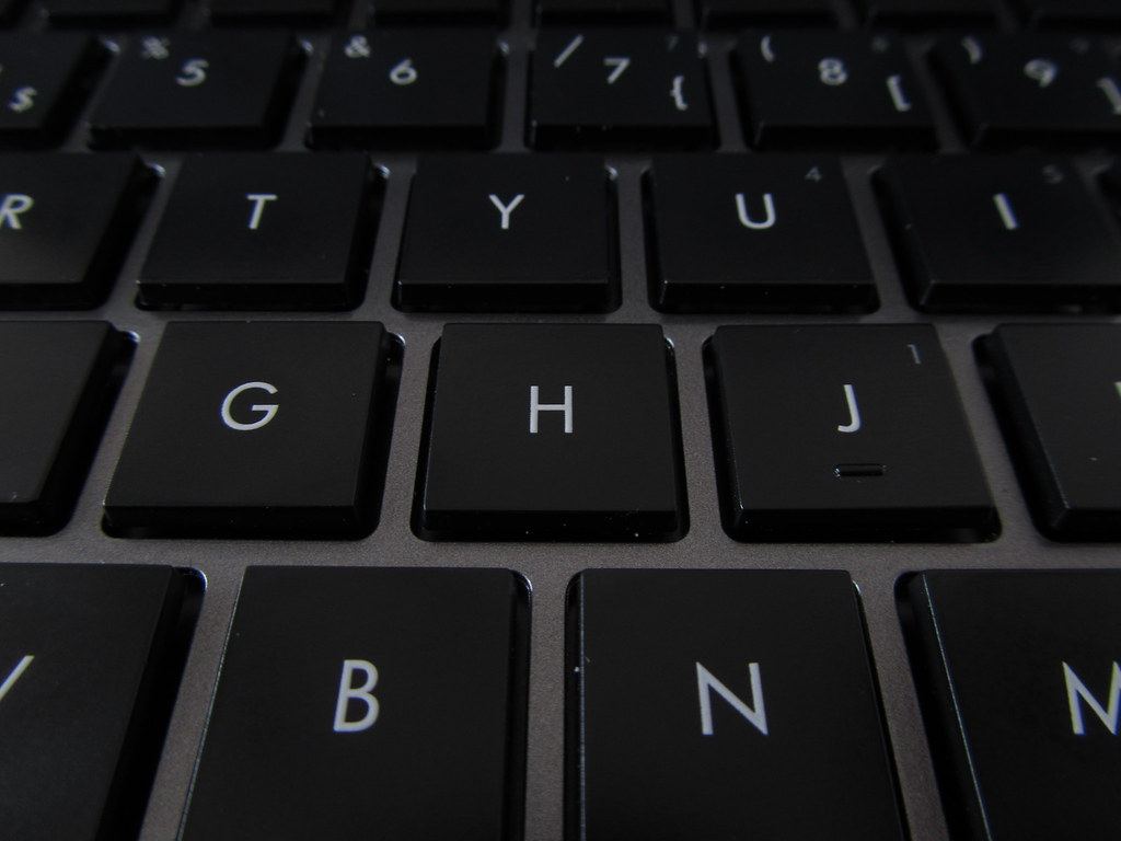 Close-up of black laptop keyboard keys with white letters, focused on the G, H and J keys